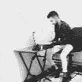 a man is sitting in front of a desk with a laptop on it .