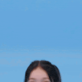 a girl with pigtails and a necklace is wearing a white shirt and making a funny face .