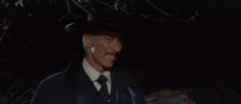 a man with a mustache wearing a hat and a blue coat