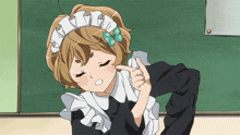 a girl in a maid outfit is pointing to her face