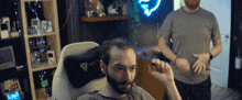 a man with a beard is sitting in a chair with a secretlab pillow