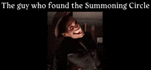a man in a hat is smiling in a dark room .