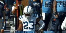 a football player with the number 23 on his jersey stands on the field