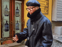 a man wearing glasses and a black leather jacket