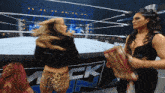 two women in a wrestling ring with a sign that says smackdown on it