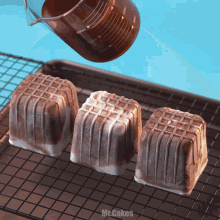 three ice cream cubes are sitting on a cooling rack with a measuring cup that says 300ml on it