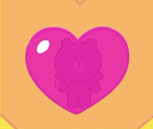 a brown teddy bear is inside of a pink heart .