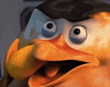 a close up of a cartoon penguin making a funny face with its mouth open .