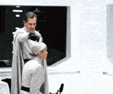 a man in a white cape stands next to a woman
