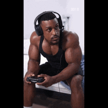 a man wearing headphones is playing a video game with the year 2018 on the bottom right