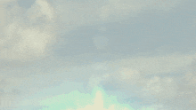 a person in a superhero costume is flying through a cloudy sky