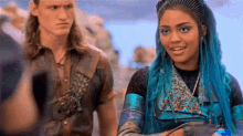 a man and a woman are standing next to each other . the woman is wearing blue hair .
