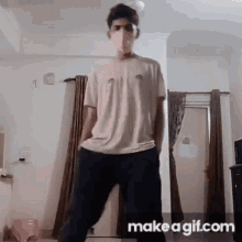 a young man wearing a mask and glasses is dancing in a room .