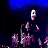 a man and a woman are dancing on a stage in front of a crowd of people .