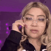 a woman wearing glasses is talking on a phone