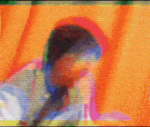 a blurred image of a person 's face with a rainbow colored background