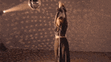 a woman is holding a microphone and singing into it while dancing .