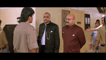 a group of men are standing next to each other in a room talking to a police officer .