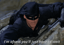 a man in a black mask with the words i 'm afraid you 'll just have to wait