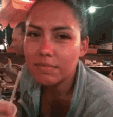 a woman with a red nose is sitting at a table with a glass of water .