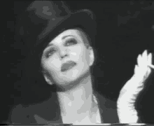 a woman wearing a top hat and white gloves smoking a cigarette