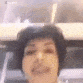a close up of a woman 's face with a blurred background .