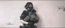 a woman is holding a gun in front of a wall that says ncsmw.com.ua
