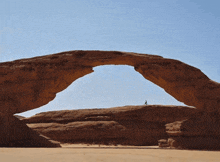 a green letter k is above a large rock formation