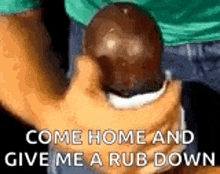 a person is holding a black ball in their hand with the words `` come home and give me a rub down '' written on it .