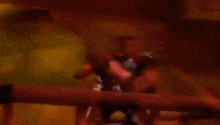 a blurry picture of a man standing at a table in a room .