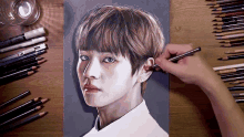 a person is drawing a portrait of a boy with colored pencils