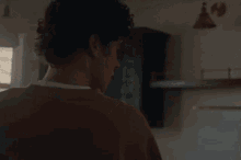a man is standing in a kitchen holding a box .