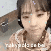 a young girl is making a funny face with stars on her face .