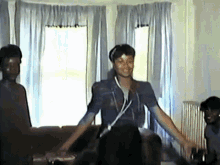 a group of people are gathered in a living room with a woman wearing headphones