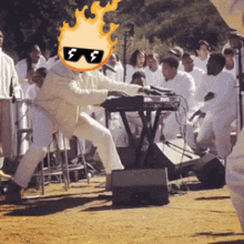 a man wearing sunglasses has a flaming head and is playing a keyboard