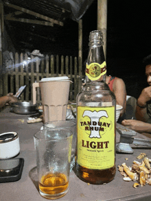 a bottle of light rum sits on a table next to a glass