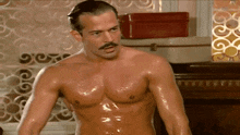 a shirtless man with a mustache is standing in front of a red box