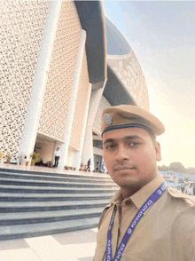 a man standing in front of a building with a lanyard around his neck that says ' kolkata police '