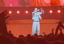 a man singing into a microphone on a stage