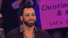 a man with a beard is holding a sign that says christian & n let 's
