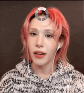 a person with red hair is wearing ear buds