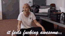 a woman sitting on the floor with the words " it feels fucking awesome " on the bottom