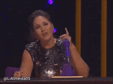 a woman sitting in front of a microphone with the hashtag lialmeida05 on the bottom of the screen