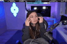 a woman is sitting in a chair with a microphone and a screen behind her that says simply