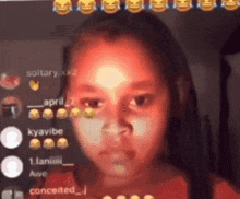 a girl with dreadlocks is looking at the camera in front of a bunch of smiley faces .