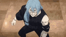 a man with blue hair and stitches on his arms is standing on a tiled floor .