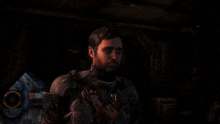 a man with a beard is holding a gun in his hand