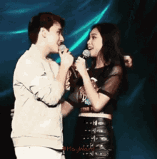 a man and a woman singing into microphones with maywarl written on the bottom of the image