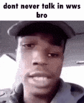 a man in a hat is making a funny face while talking to someone .