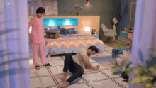 a woman standing next to a man kneeling on the floor